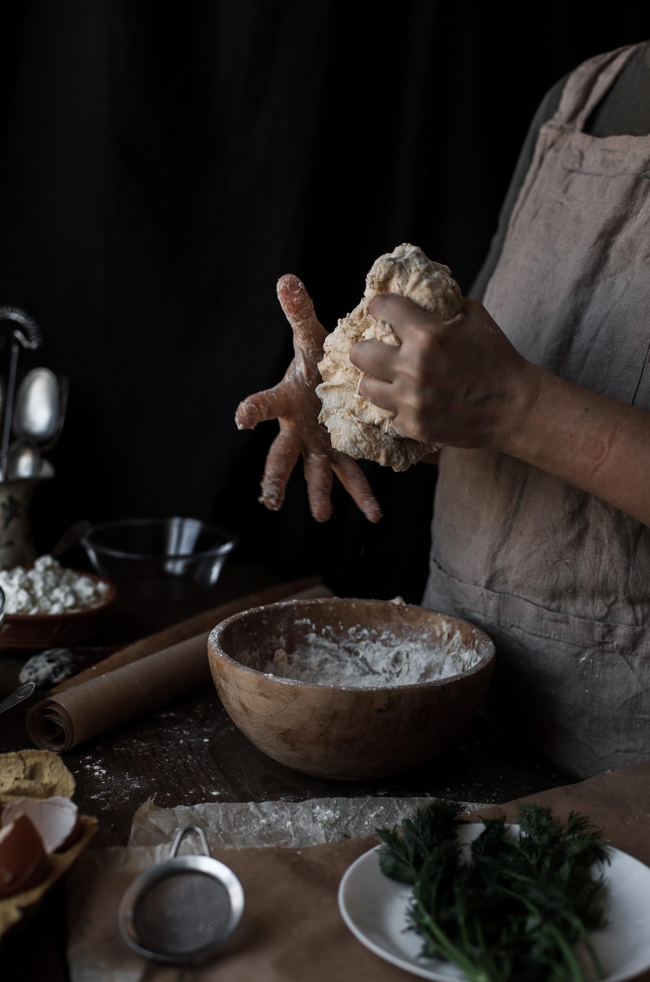 Hands kneading dough in rustic kitchen
